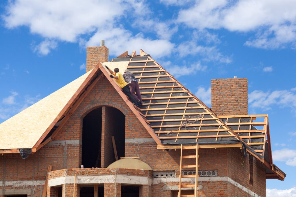 House,Under,Construction.,Workesr,Installing,Fibreboard,On,The,Roof
