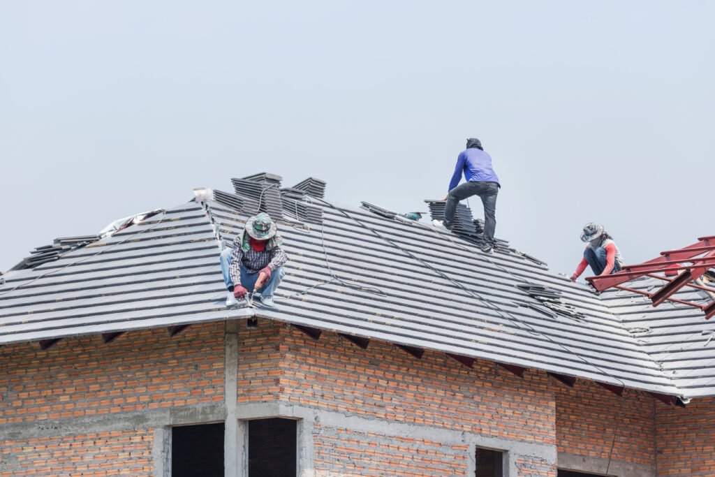 Workers,Installing,Concrete,Tiles,On,The,Roof,While,Roofing,House